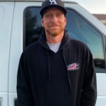 unnamed-2 Smiling man in a hoodie by a van.