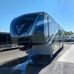 20220512_095241 Sleek Voltage RV parked under a clear blue sky.