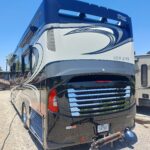 20220701_124826 Luxury RV parked under clear blue sky.