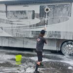 20220909_073449 Person washing an RV with soap and water.