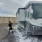 20220909_073458 Person washing an RV with soap and water.