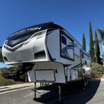 IMG_0582 Parked fifth-wheel RV under clear blue sky.