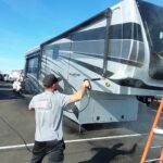 VideoCapture_20230118-155537 Person washing a large RV in clear weather.