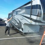 VideoCapture_20230118-155619 Person washing a large RV in sunlight.