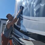 VideoCapture_20250324-143933 Person cleaning an RV on a ladder.